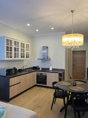 a kitchen with a table and a dining room at Albatross Relax seaside in Ķesterciems
