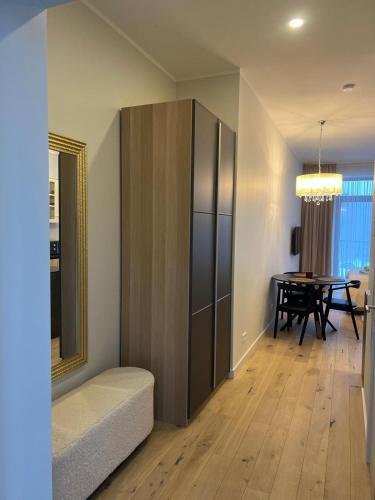 a living room with a table and a large cabinet at Albatross Relax seaside in Ķesterciems