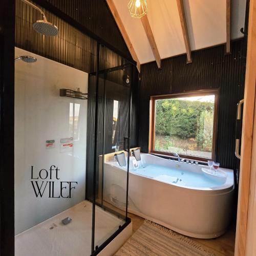 a large bathroom with a tub and a window at Loft Wilef in Tentén