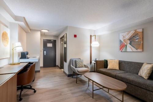 a living room with a couch and a table at Holiday Inn Hotel & Suites London by IHG in London