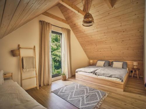 a bedroom with two beds and a large window at Chalet Plechovka in Frýdštejn
