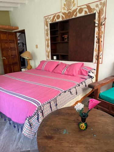 a bedroom with a large bed with pink sheets at House 3 blocks from downtown in Tepoztlán