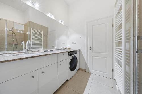 a white kitchen with a sink and a washing machine at EUPHORAS - Central & Stylish Apartment - Parking in Bad Harzburg