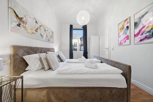 a bedroom with a large bed with white sheets at EUPHORAS - Central & Stylish Apartment - Parking in Bad Harzburg