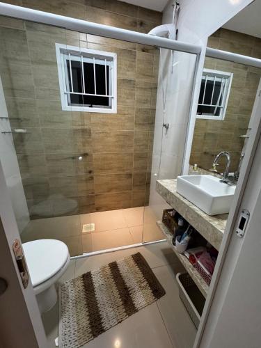a bathroom with a toilet and a sink at Excelente casa com piscina próx ao Mar in Capão da Canoa