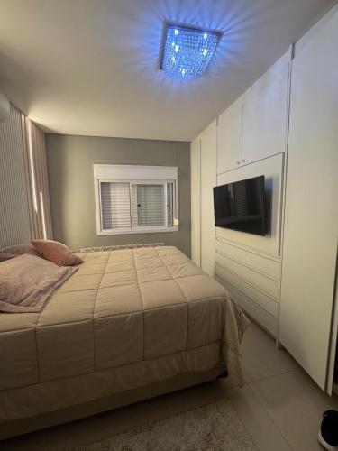 a bedroom with a bed and a tv on the ceiling at Excelente casa com piscina próx ao Mar in Capão da Canoa