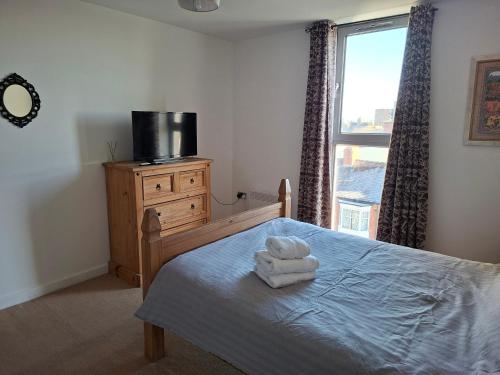 a bedroom with a bed with two towels on it at Elegant three bedroom flat in Darlington