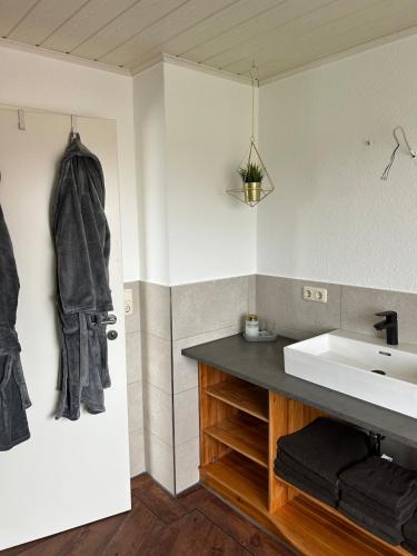 a bathroom with a sink and a towel hanging on the wall at Michaels Elbtraum in Drochtersen
