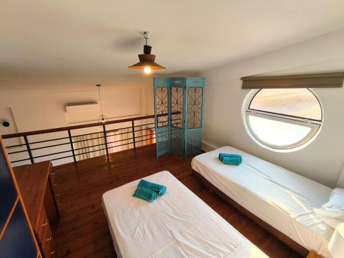 two beds in a room with a window at Psalidi beach loft house in Psalidi