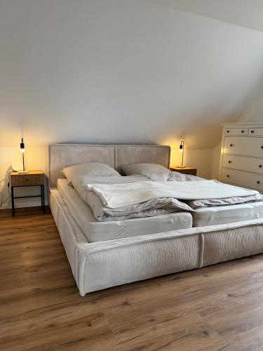 a white bed in a bedroom with two nightstands and lamps at Michaels Elbtraum in Drochtersen