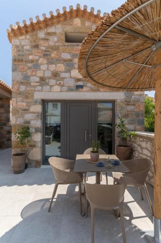 a patio with a table and chairs in front of a building at petra apartments apartment No3 in Methoni