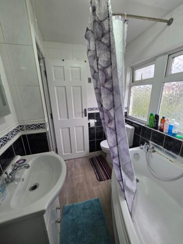 a bathroom with a sink and a tub and a toilet at Fenia Estate in Barking