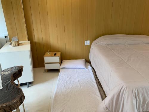 a small bedroom with two beds and a small table at Conchas Lofty in Governador Celso Ramos