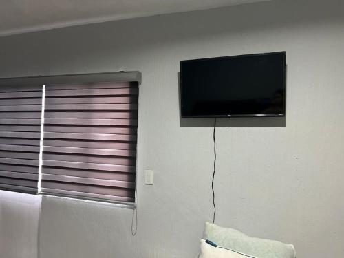 a flat screen tv on a wall next to a window at Alojamiento en el centro de tlaquepaque in Guadalajara