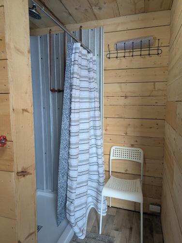 a sauna with a white chair and a towel at Field and Fern Cottages in Tatamagouche