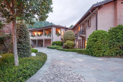 a courtyard of a house with bushes and trees at Il Portico - 1711 Luxury Guest House in Arlate