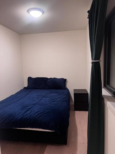 a bedroom with a blue bed and a window at Modern Flat In Flateby, Enebakk in Flateby