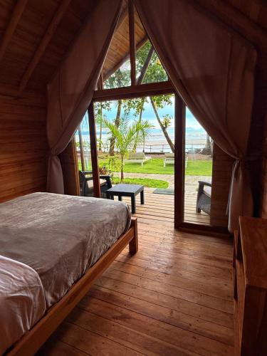 a bedroom with a bed and a view of the ocean at Hotel Oasis & Surf Camp in Santa Catalina