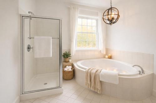 a white bathroom with a tub and a window at Catskill Cabin with Firepit & Indoor Jacuzzi Tub in Catskill