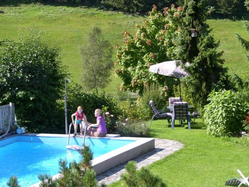 two children are playing in a swimming pool at Gästehaus Elisabeth in Radstadt