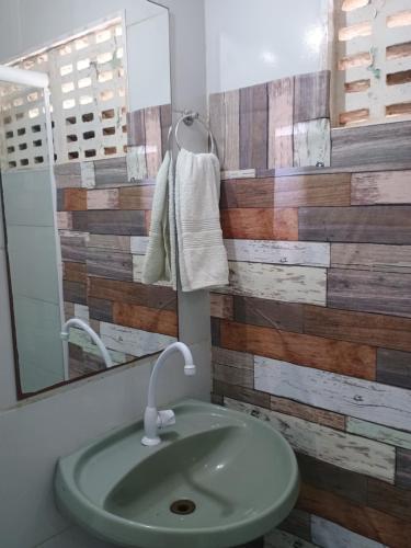 a bathroom with a green sink and a mirror at Flats Mundos Golfinhos in Pipa