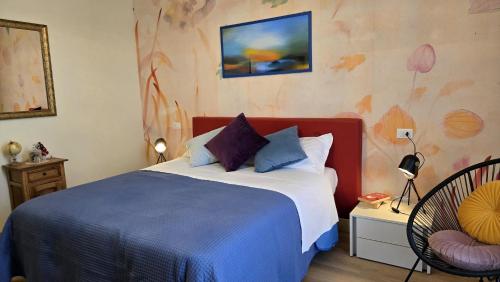 a bedroom with a large bed and a chair at Residence Casa del Moro in Minerbio