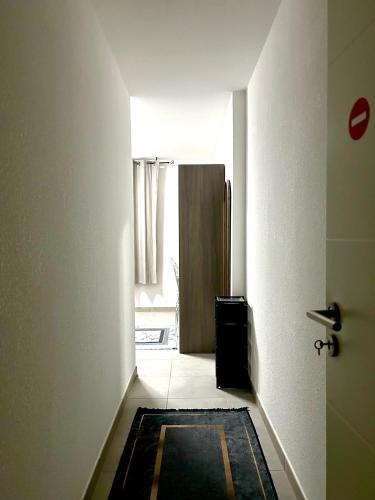 a hallway with a door and a rug in a room at Chambre privée chez habitant à Sète in Sète