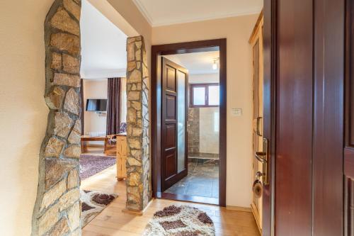 a hallway with a door and a stone wall at Pensiunea Valceaua Zanelor in Stațiunea Climaterică Sâmbăta