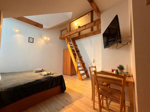 a bedroom with a loft bed and a desk with a television at Villa Apartments in Palanga