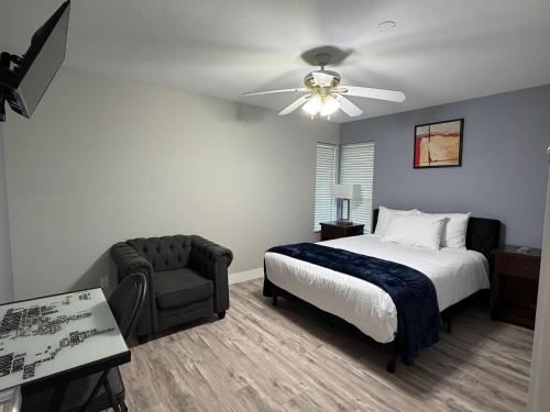 a bedroom with a bed and a chair and a ceiling fan at J & J Dream Villa Ltd in Abbotsford
