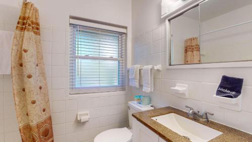 a bathroom with a toilet and a sink and a mirror at Atlantic Breeze #8 in Jekyll Island