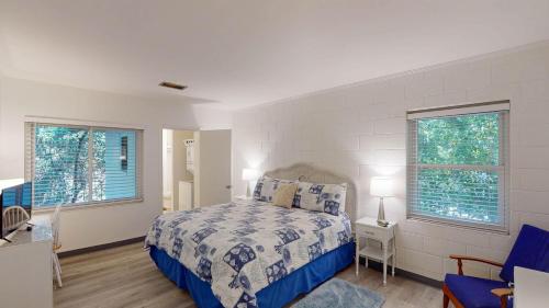 a bedroom with a bed and two windows at Atlantic Breeze #8 in Jekyll Island