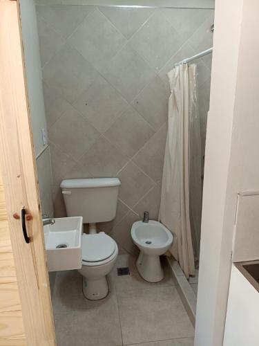 a bathroom with a toilet and a sink at Hospedaje Costanera del Sol in La Adela