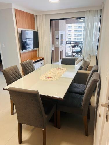 a dining table and chairs in a living room at Apartamento perto da Praia em Itapema!!! in Itapema