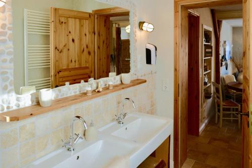 a bathroom with two sinks and a mirror at BEACHHOUSE Fehmarn in Fehmarn