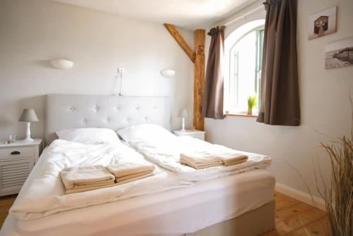 a white bed with two towels on it in a bedroom at BEACHHOUSE Fehmarn in Fehmarn