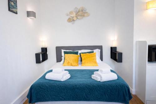 a bedroom with a bed with two towels at L'Agapanthe - Proche Gare in Saint-Pierre-des-Corps