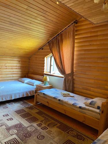 a room with two beds and a window at Karpatska Mria in Yaremche