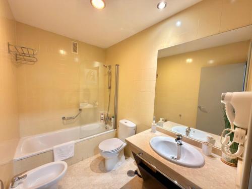 a bathroom with a sink and a toilet and a tub at ApartSur® in Bormujos