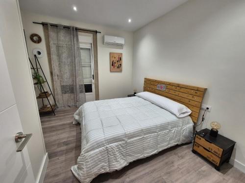 a bedroom with a large bed and a window at Escola in Ourense