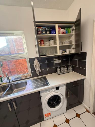 a kitchen with a washing machine and a sink at Pat Signature Stays in Kingsthorpe