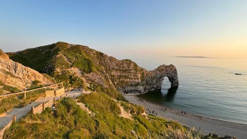 a view of a beach with an arch in the water at Durdle Door Hotel in Lulworth Cove