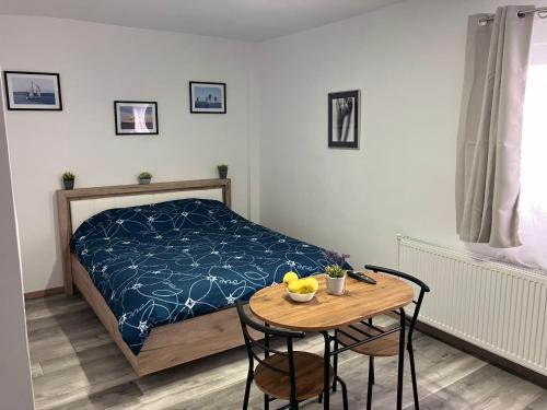 a bedroom with a bed and a table with two chairs at Garsoniera Goldis in Arad