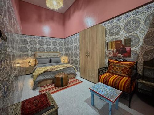a bedroom with a bed and a table and a couch at Riad Dar Fassi in Rabat
