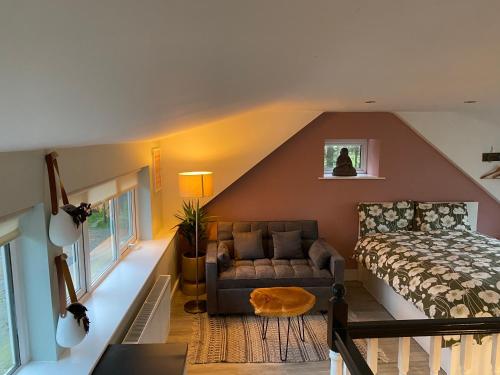 a attic bedroom with a bed and a couch at Quiet countryside retreat in Cork