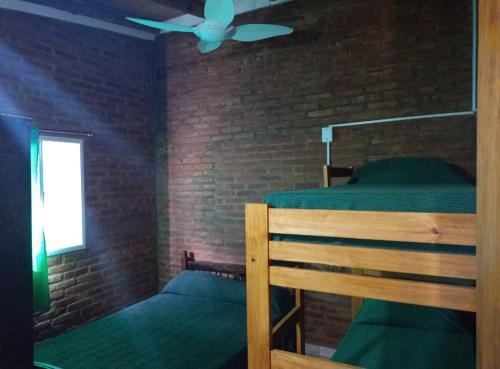 a bedroom with a bunk bed and a ceiling fan at Mi Niña's in Villa Cura Brochero