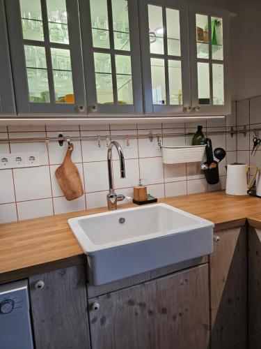 a kitchen with a white sink and some windows at Kakasvári Vendégház in Gömörszőlős