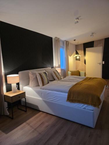 a bedroom with a large white bed and a chair at Ferienhaus Lyś in Lauta