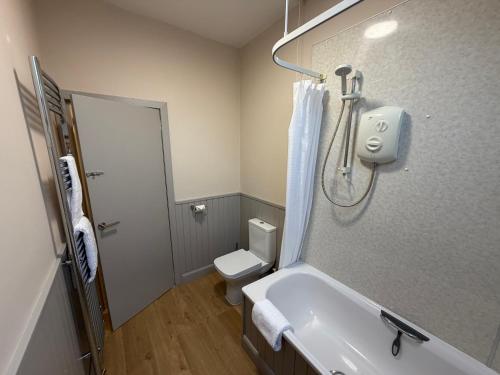 a bathroom with a tub and a toilet and a sink at Roods Apartment in Angus