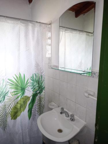 a white bathroom with a sink and a mirror at Mi Niña's in Villa Cura Brochero